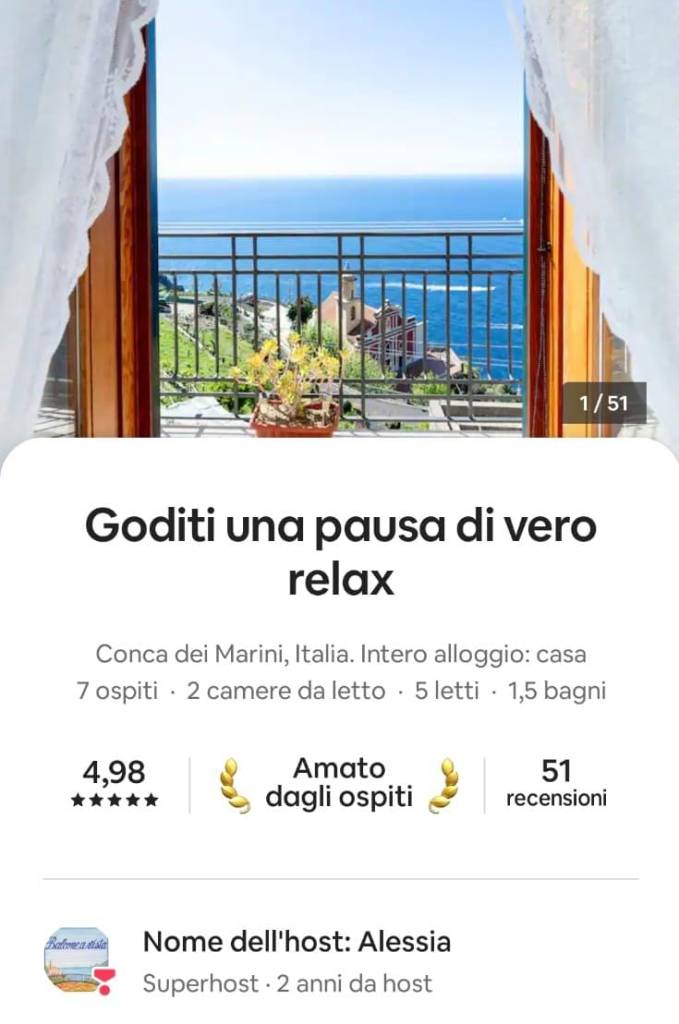 Vista panoramica sul mare dalla finestra di una casa in Italia, con piante in vaso e un cielo sereno.